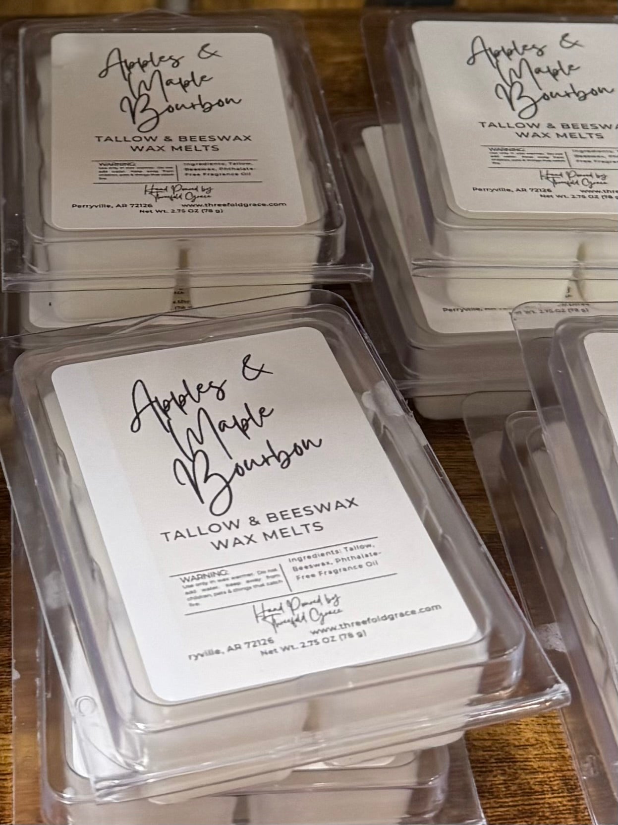 Wax melts packaging with 'Apples & Maple Bourbon' label on a wooden surface