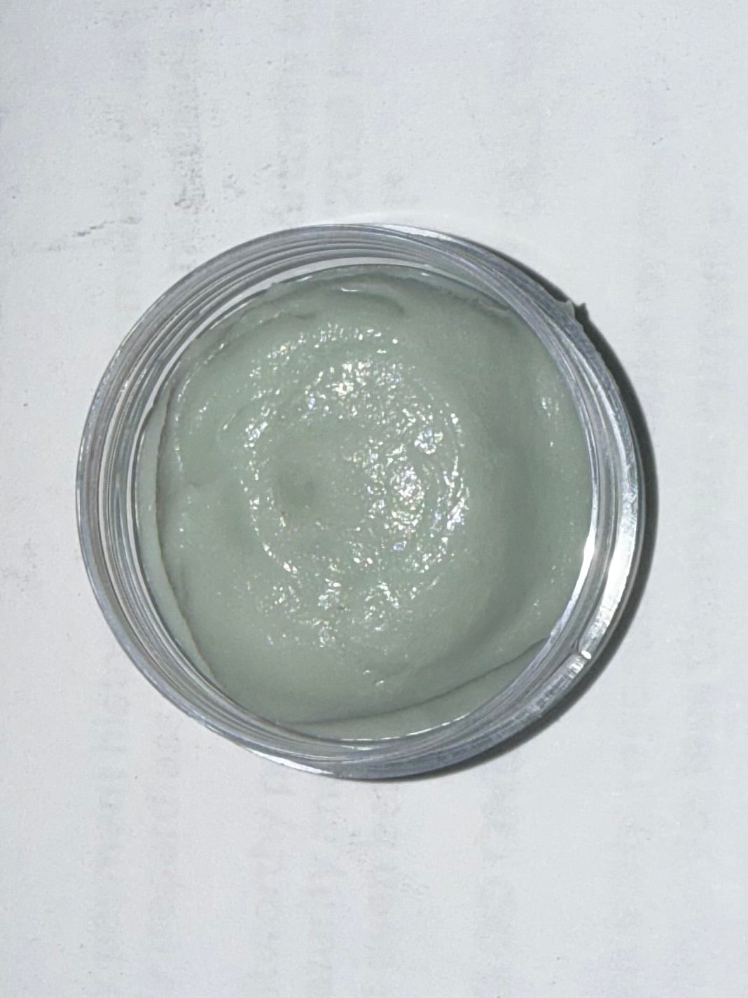 Jar of green magnesium tallow cream with blue yarrow